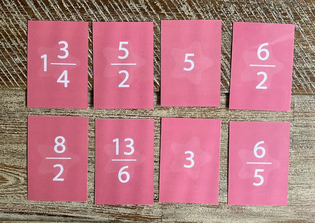 Huit cartes du jeu avec des fractions, des nombres mixtes et des nombres entiers (1 3/4, 5/2, 5, 6/2, 8/2, 13/6, 3, 6/5).